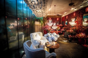 Un intĂ©rieur luxueux agrĂ©mentĂ© dâun coin salon, de plantes dĂ©coratives et dâun lustre.