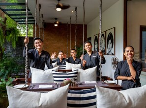 Un grupo de personas en un restaurante con una decoración rústica, que incluye paredes de ladrillo visto y cuerdas colgantes.
