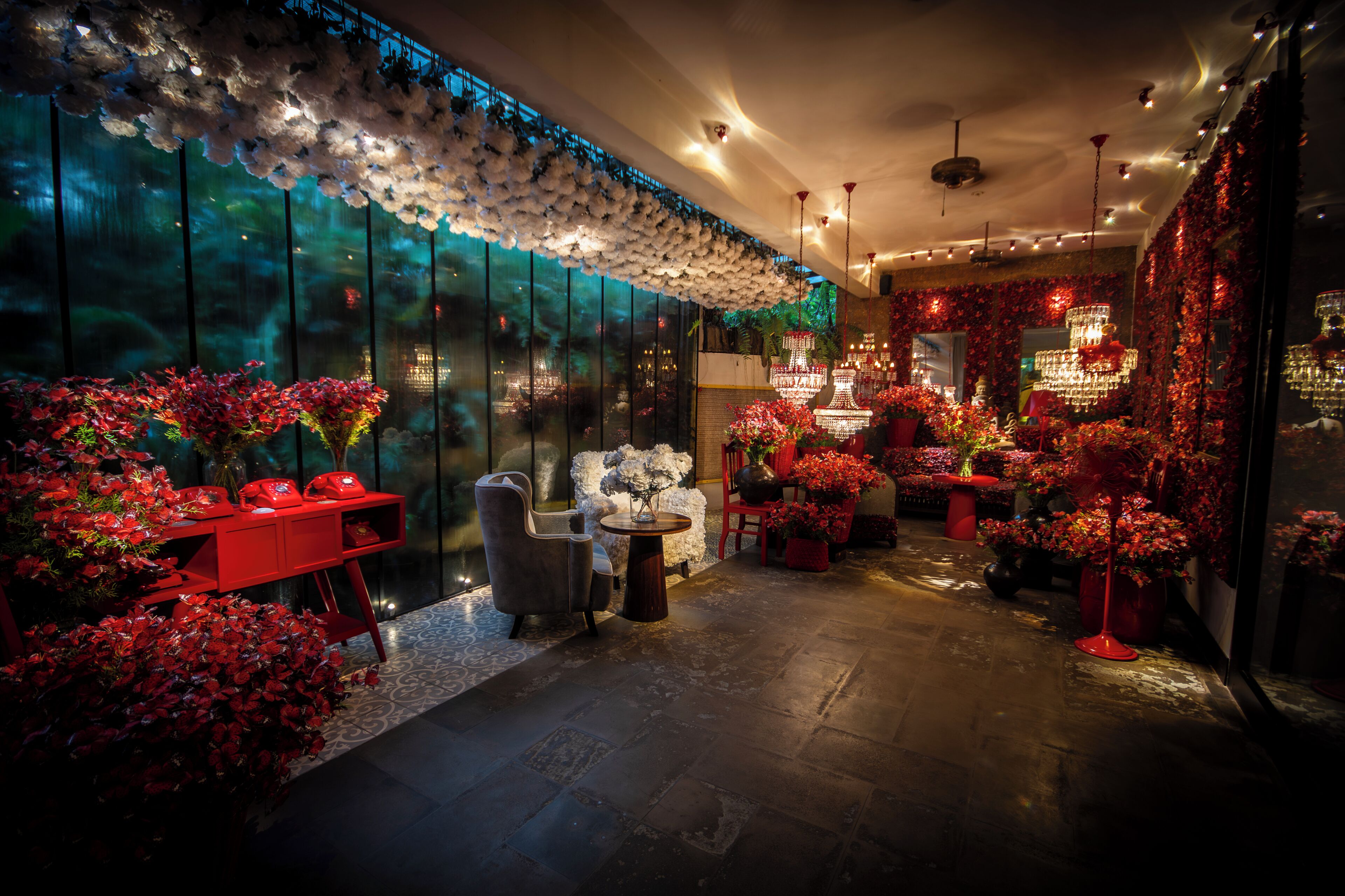 Un intérieur moderne avec un coin salon, un lustre et une grande fenêtre offrant une vue dégagée.