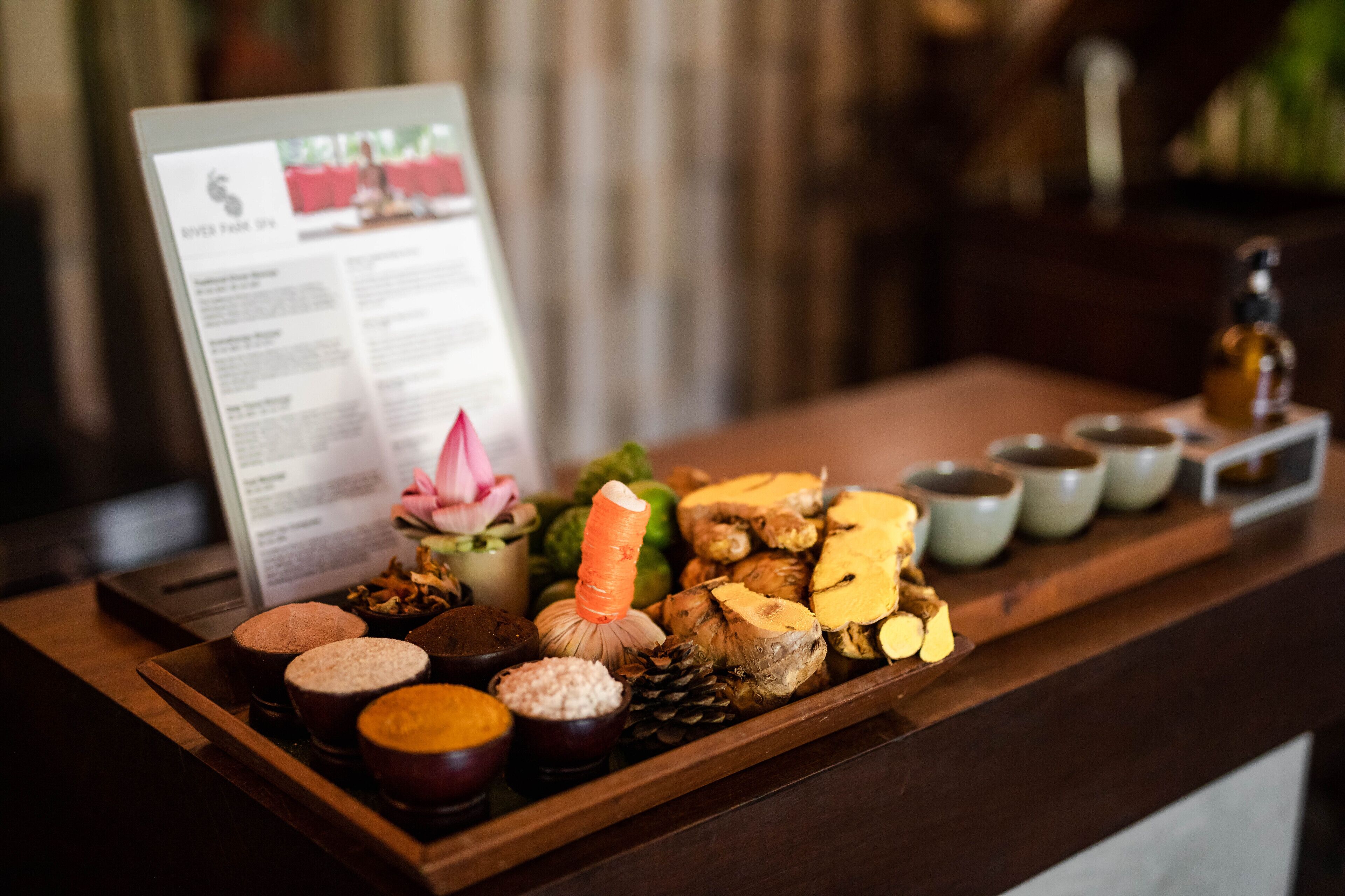 Uma bandeja com diversos alimentos e um letreiro de menu em um balcão de madeira.