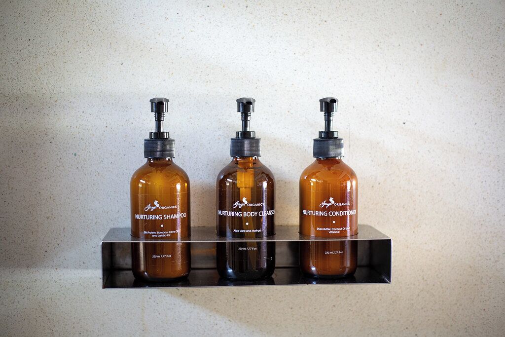 Drie flessen 'Nurturing' producten staan op een plank.