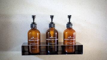 Drie flessen 'Nurturing' producten staan op een plank.