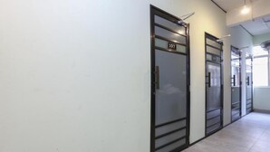 A hallway with doors labeled 107 and 108, featuring a modern design with glass panels and metal frames. - Hotel O The Space Inn (Kuala Terengganu)