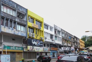 Una hilera de edificios de varios pisos con diversos comercios y negocios, incluyendo un letrero visible que dice 'Space Inn'.