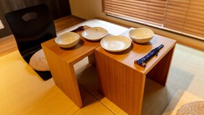 A traditional Japanese tatami mat room with a low wooden table and four ceramic bowls. - The Pagoda Experience (Kyoto)