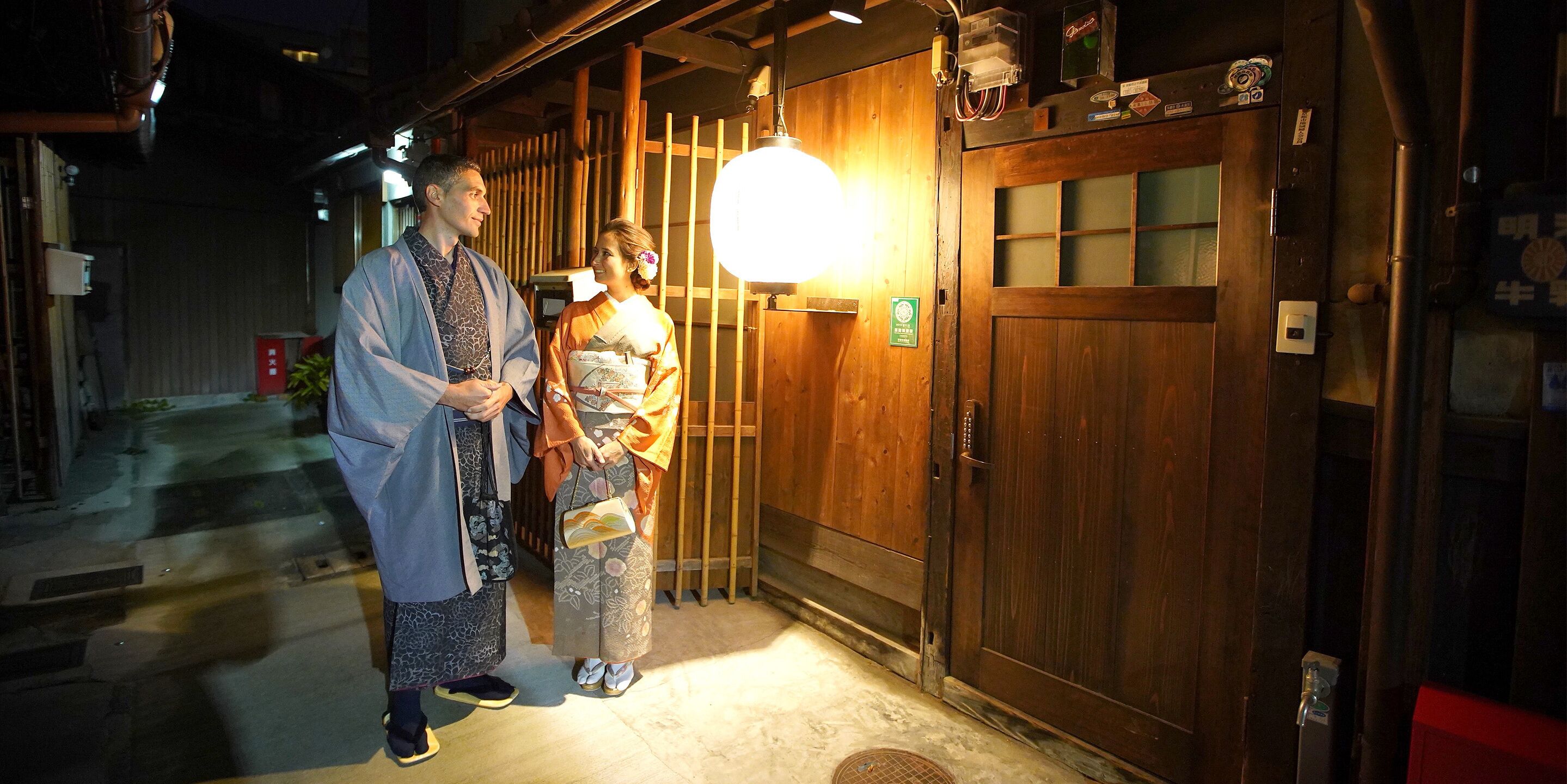 A traditional wooden building with a large door and a bright hanging light fixture.