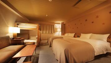 A hotel room with two beds, a sofa, a wooden table, and a lamp.