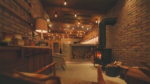 A cozy room with a brick wall, a fireplace, and a seating area with a table and chairs. - Unwind Hotel & Bar Sapporo (Sapporo)