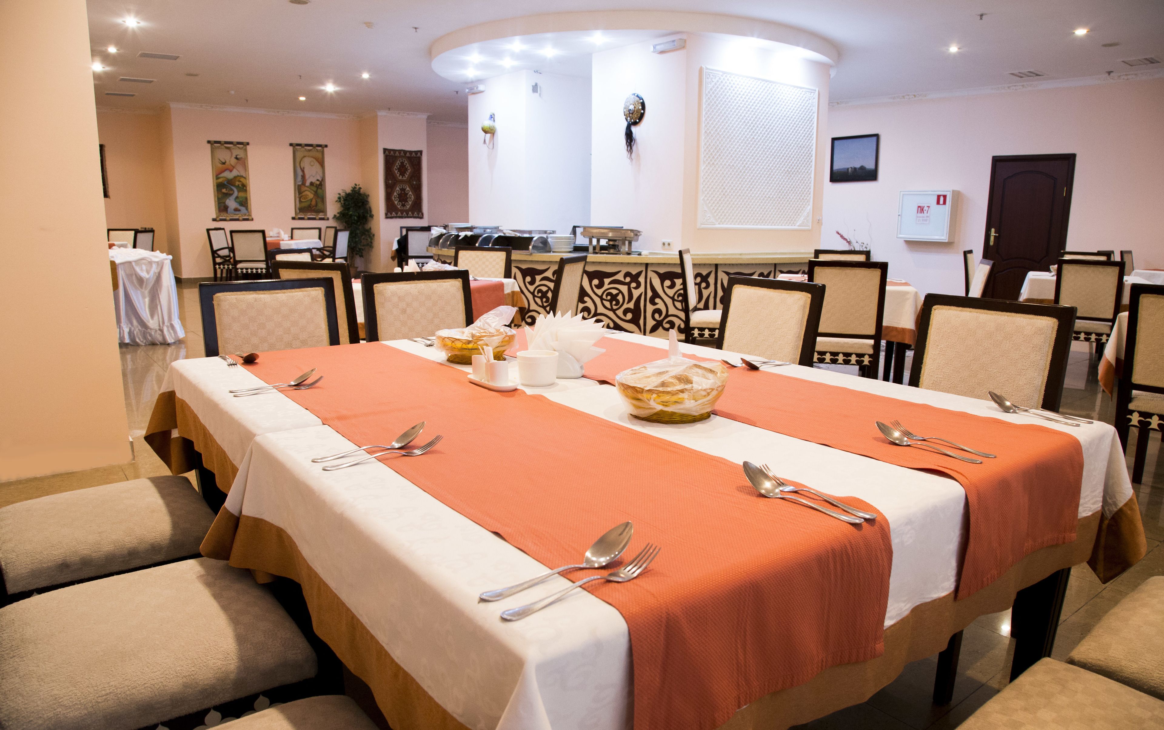 A conference room with a long table, chairs, and a buffet setup.
