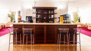Un espace bar comprenant un mini-bar, des tabourets de bar et un comptoir.
