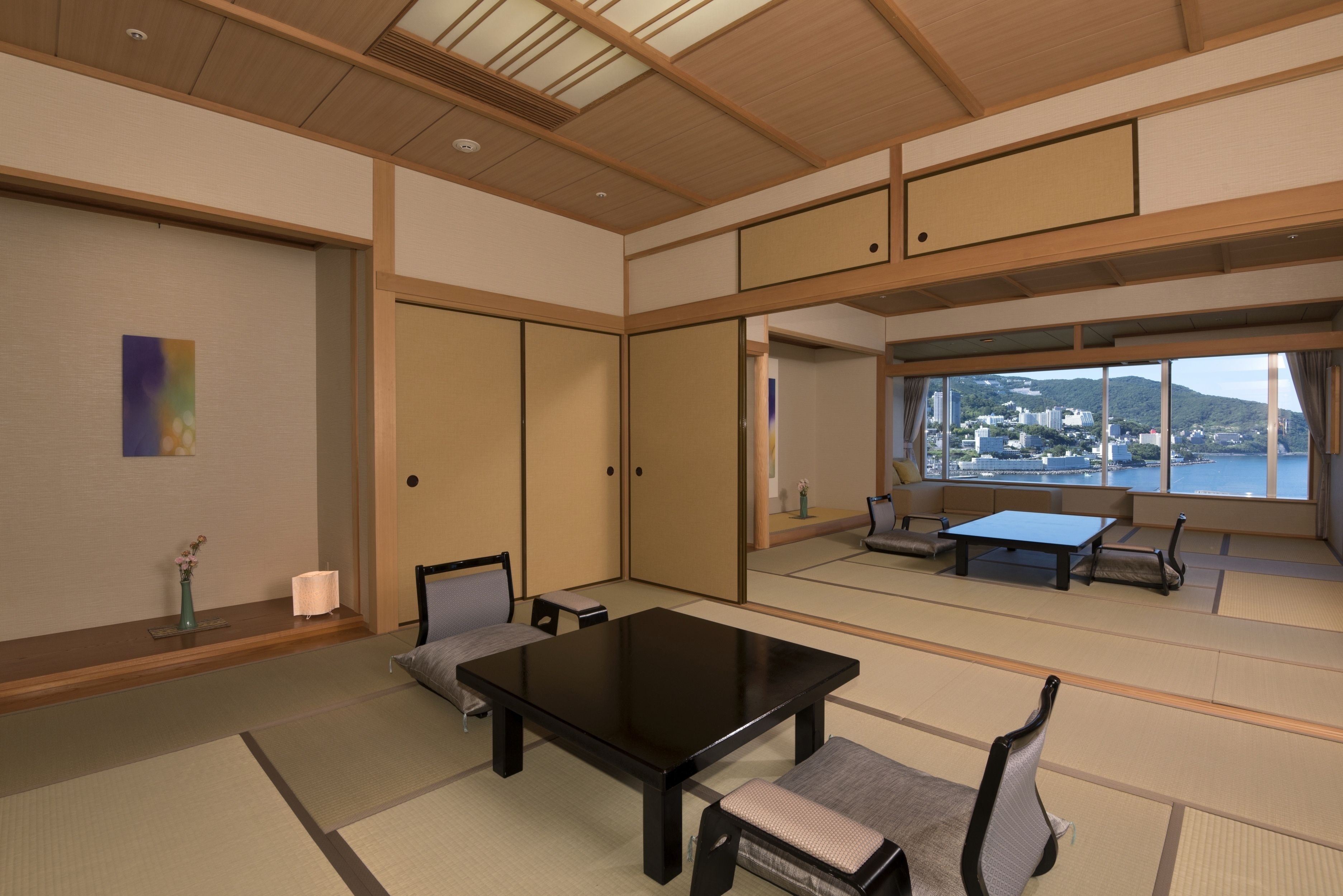 Una habitación japonesa tradicional con suelo de tatami, una mesa baja y asientos.