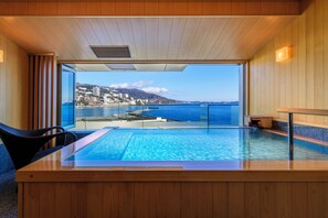 Ein moderner, überdachter Pool mit Blick auf eine Küstenstadt.