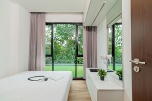 Deluxe driepersoonskamer | Luxe beddengoed, een kluis op de kamer, een bureau