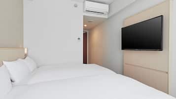 Ein Hotelzimmer mit einem großen Bett, einem an der Wand befestigten Fernseher und einer Klimaanlage.