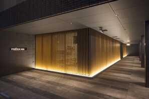 Eine moderne Hotelhalle mit einer eleganten, beleuchteten Rezeption und einem sauberen, gefliesten Boden.