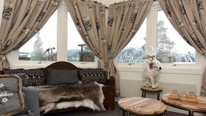 A cozy room with a sofa, a fur throw, a wooden table with glasses, and a decorative dog statue. - Hotel Mezzo (Lima)