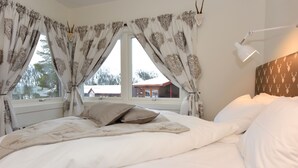 A bedroom with a large bed, a window with curtains, a bedside lamp, and a view of a building outside. - Hotel Mezzo (Lima)