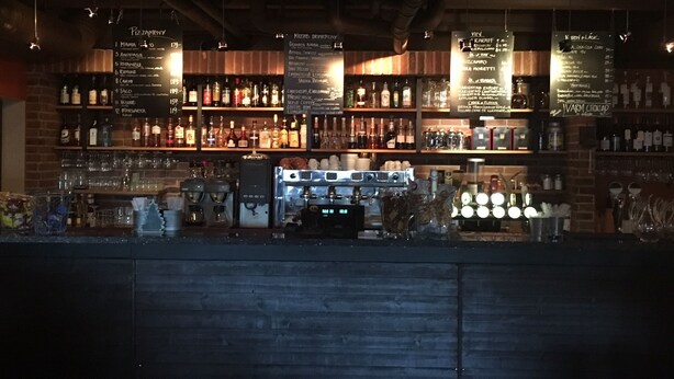 A bar with shelves of liquor bottles and a coffee machine. - Hotel Mezzo (Lima)