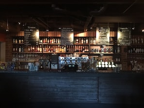 A bar with shelves of liquor bottles and a coffee machine.