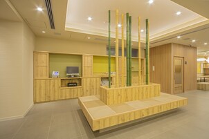 Un área de recepción con un escritorio de madera, un teléfono y una televisión.