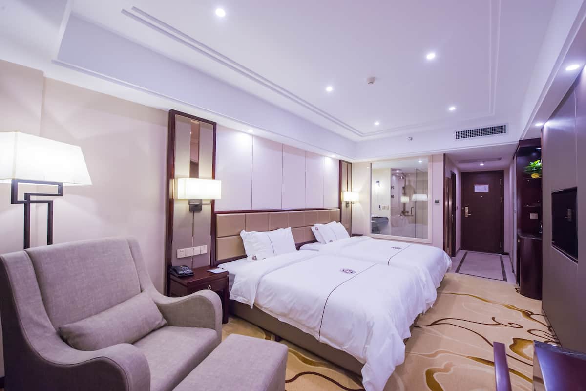 Une chambre d’hôtel avec un grand lit, un canapé, un bureau et une télévision.