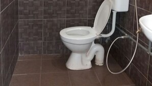 Une salle de bain équipée de toilettes, d’un bidet et d’un lavabo.