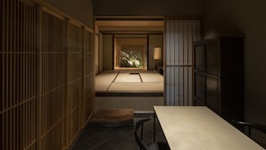 A traditional Japanese room with tatami flooring, sliding doors, and a low table. - Kamohan (Kyoto)