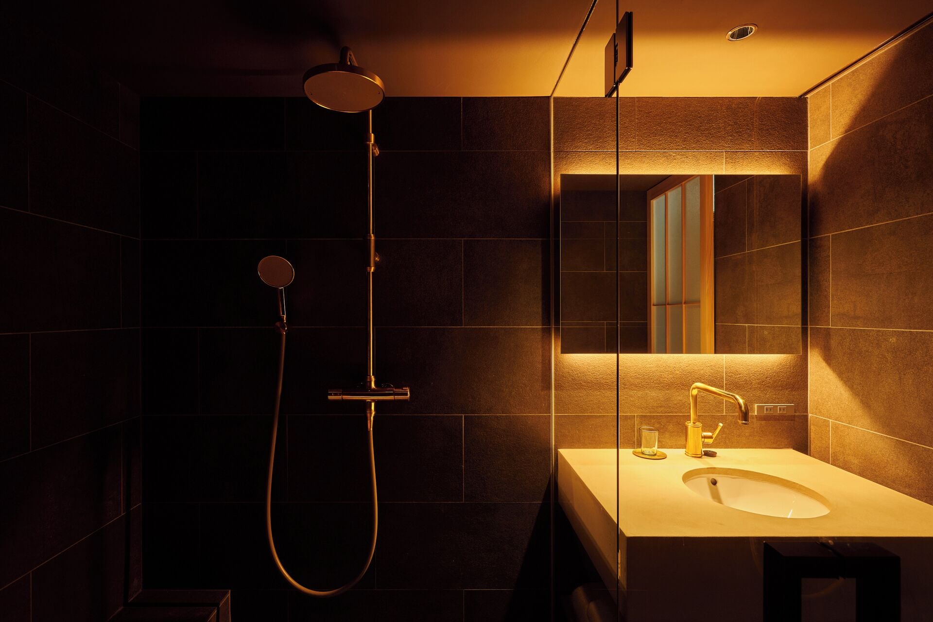 A modern bathroom with a shower, a sink, and a mirror.