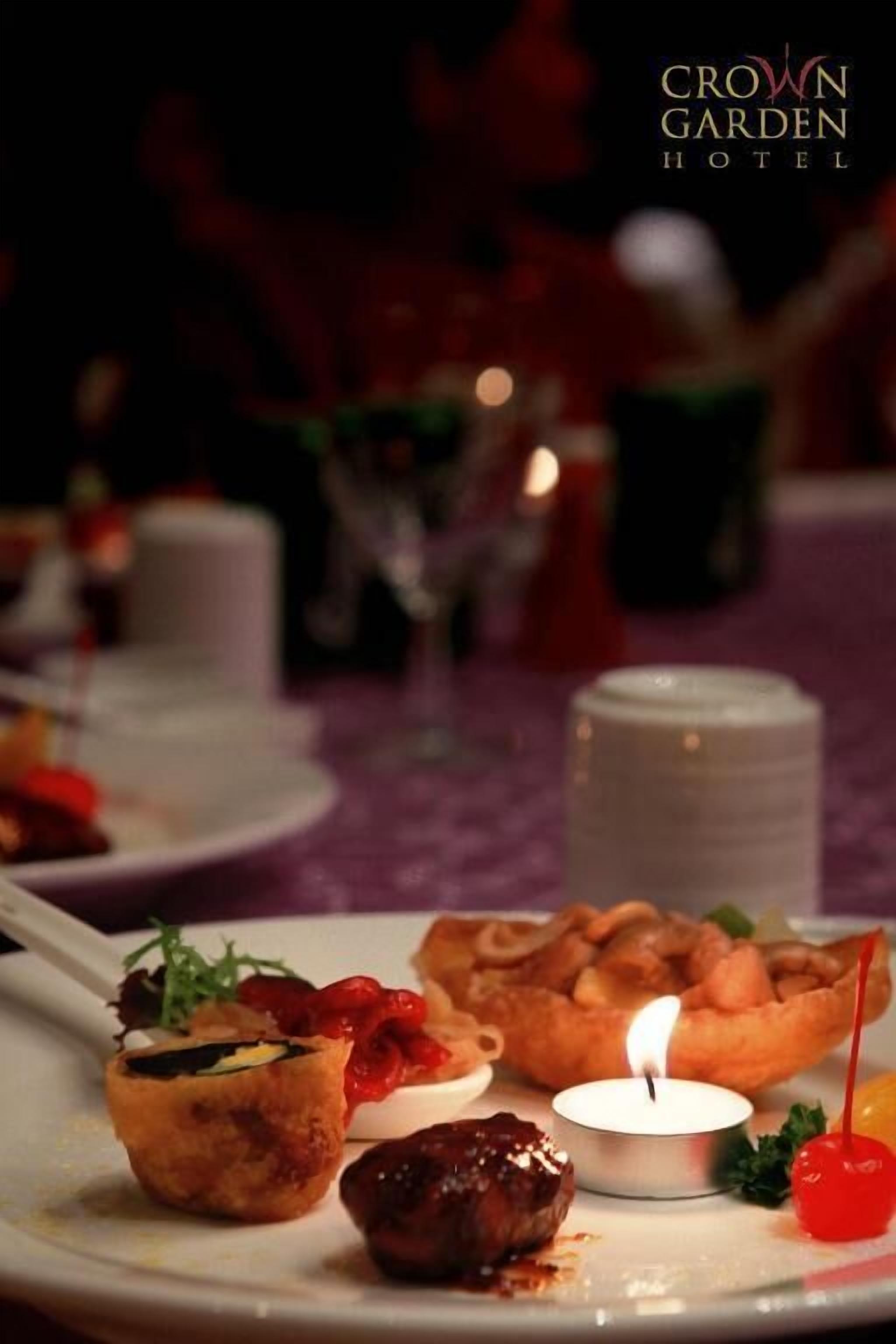 Una taula de menjador amb diversos plats, una espelma i un objecte decoratiu petit.