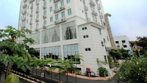 A multi-story building with a modern architectural design, featuring balconies and large windows.
