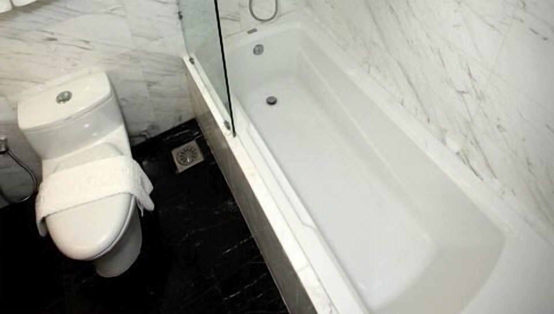 A bathroom with a toilet, a shower, and a bathtub.