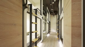A corridor with bunk beds and wooden walls. - Taiwan Youth Hostel & Capsule Hostel (Taipei)
