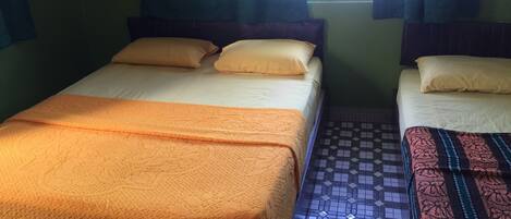 Ein Zimmer mit zwei Betten, jedes mit einer anderen Bettdecke.