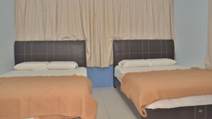 Habitación con dos camas, cada una con cabecera y almohadas, y un ventanal con cortinas.
