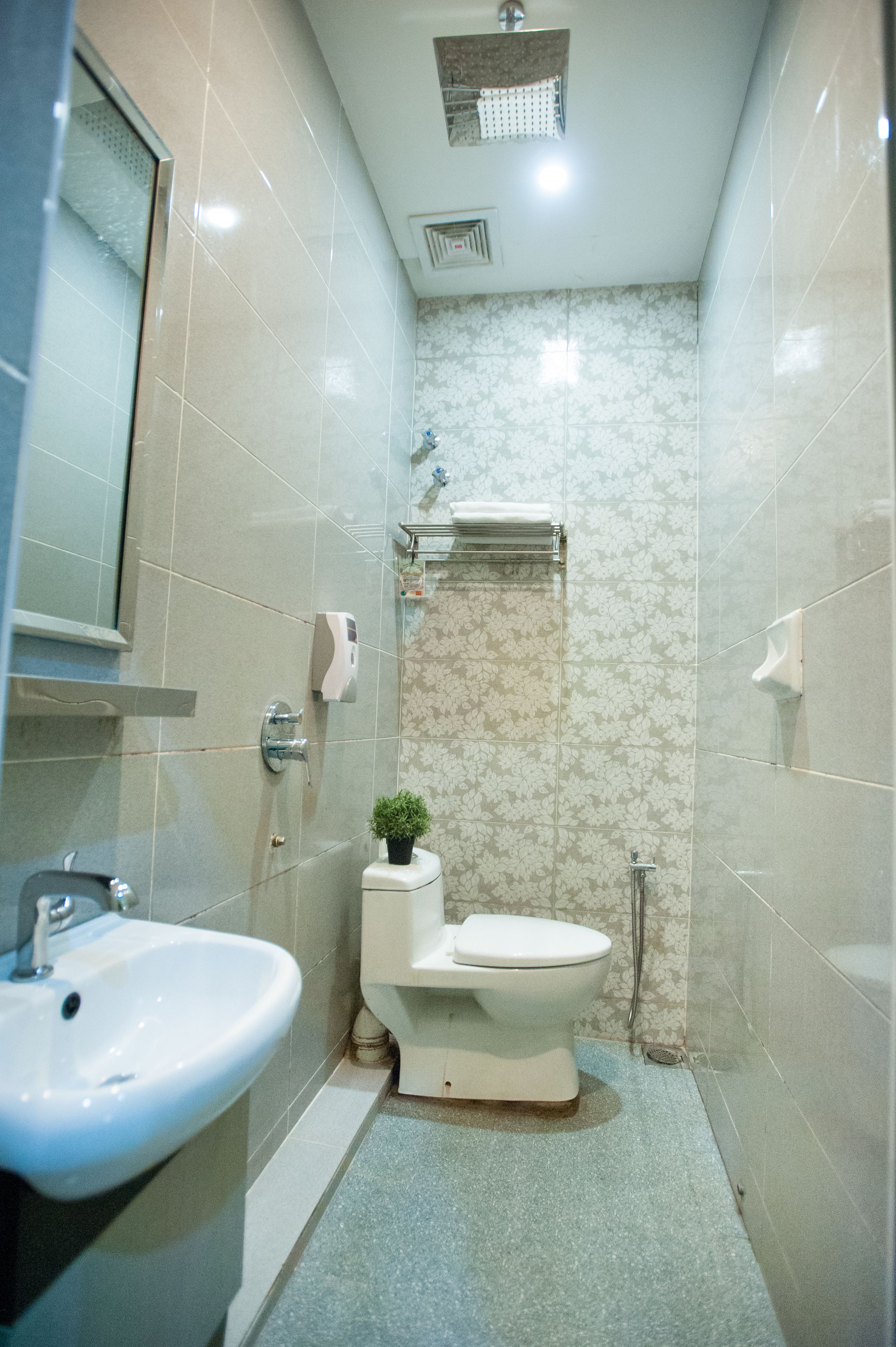 A small bathroom with a toilet, sink, and shower.