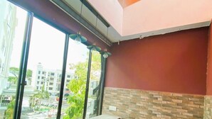 Un interior moderno con un ventanal grande, un sofá, una mesita redonda y un techo con diseño de cuadrícula.