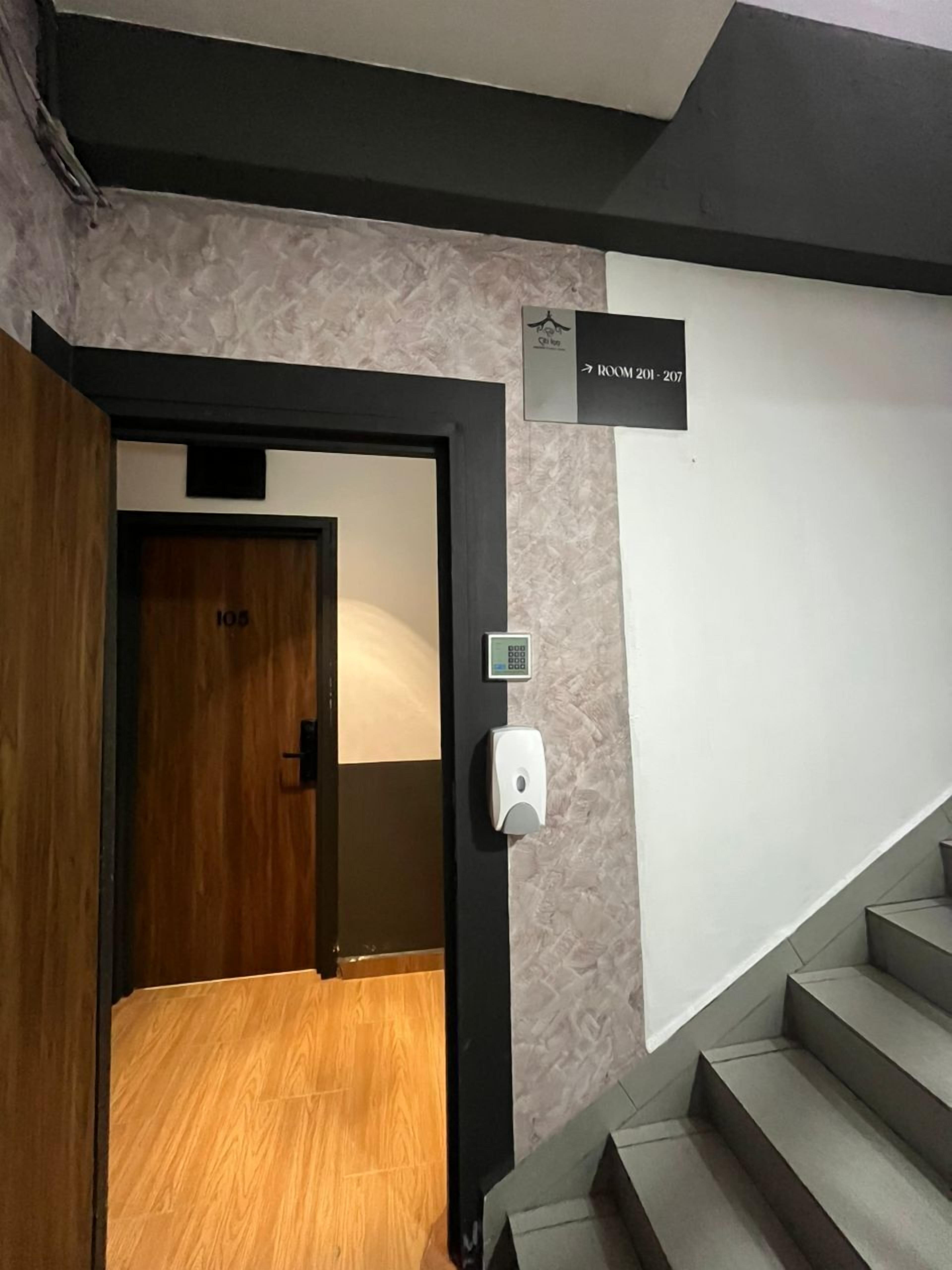 A hotel entrance with a sign indicating room 201-207.
