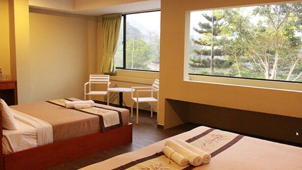 A hotel room with two beds, a small table, and chairs. - Your Hotel (Genting Highlands)