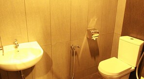Un baño con lavamanos, inodoro y ducha.