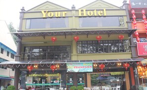 Un hotel con un letrero que dice "Your Hotel" y un cartel anunciando una promoción de bodas.
