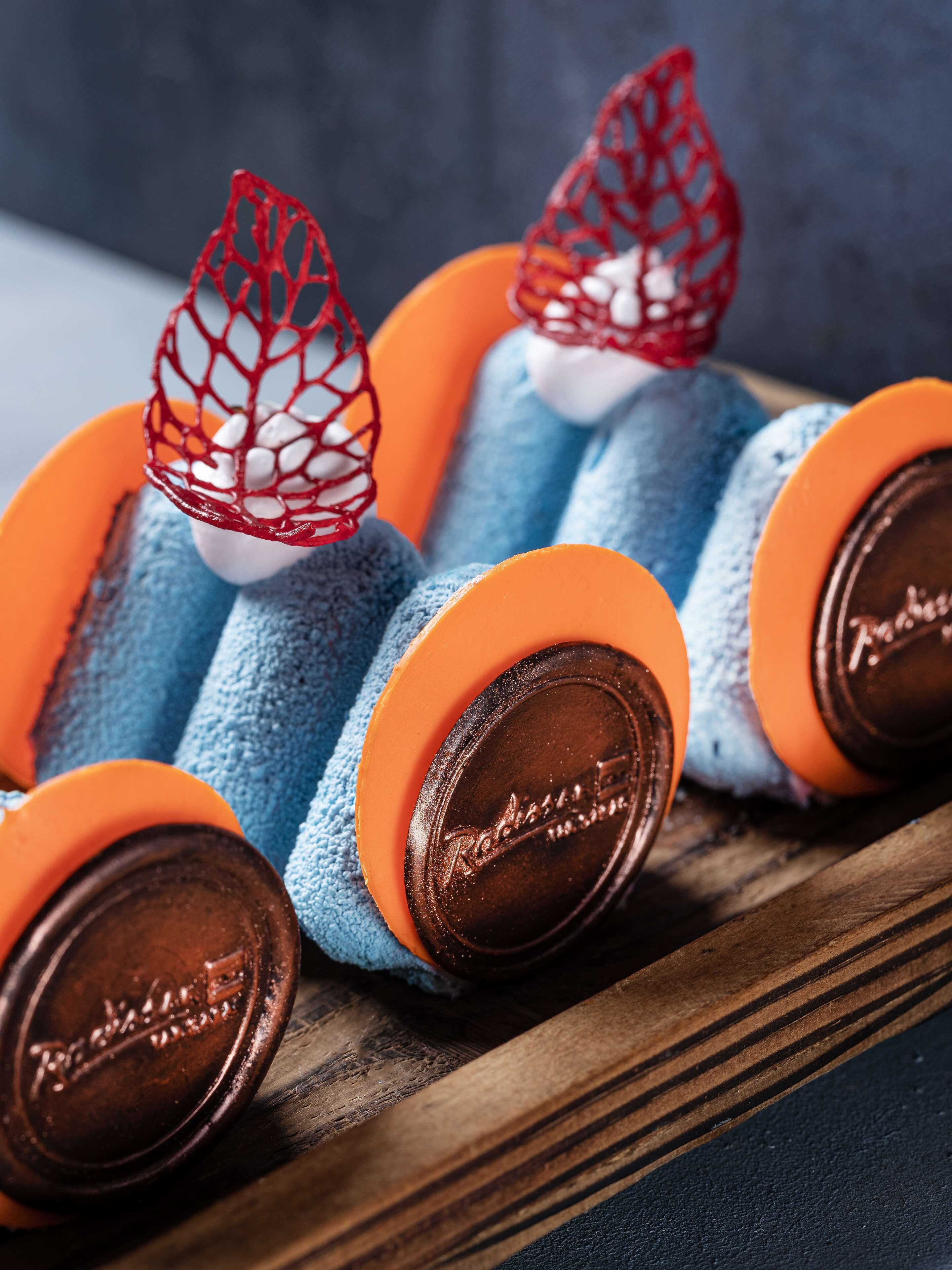 A close-up of a chocolate bar with a red netted top and a wooden base.