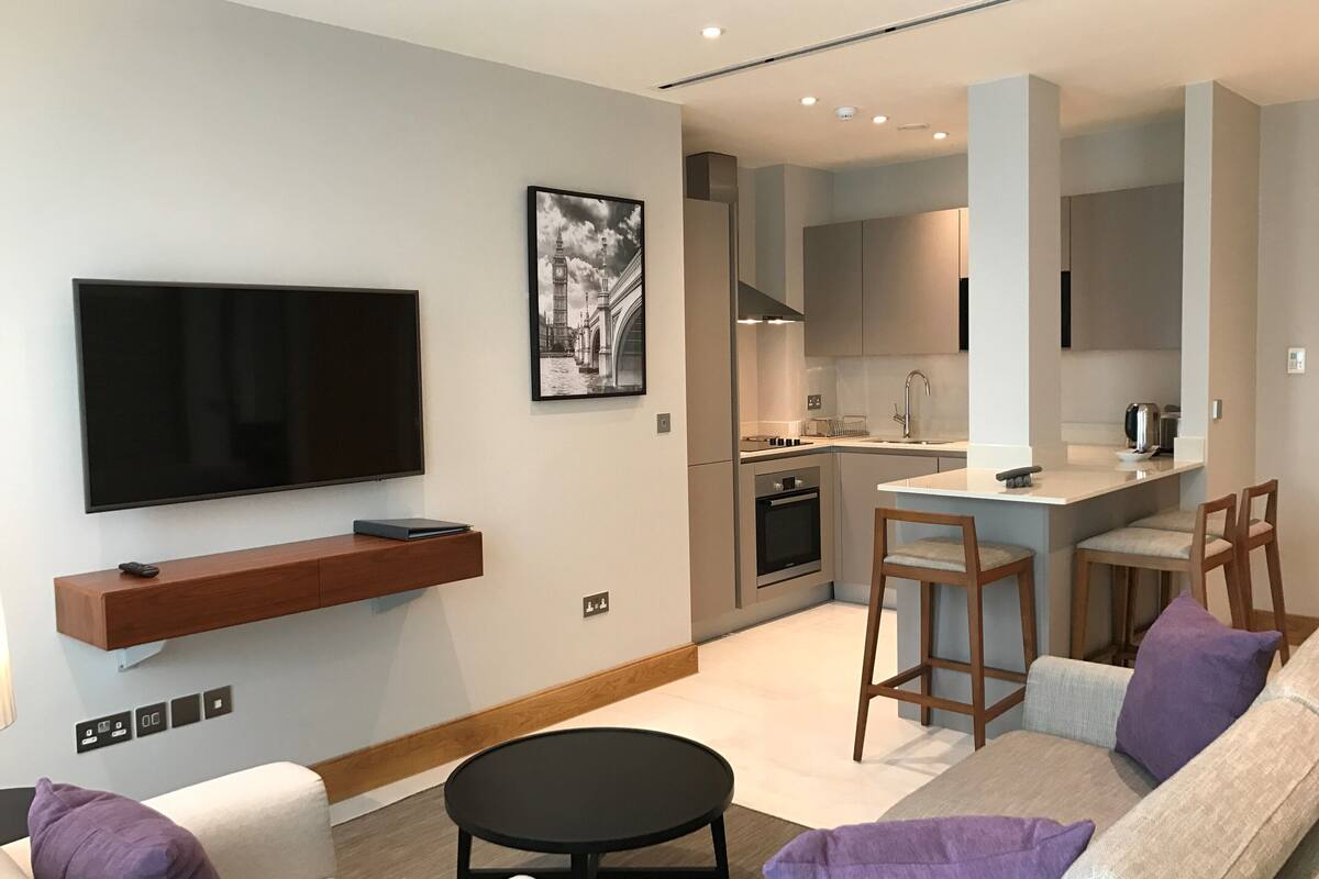 A modern living room with a flat-screen TV, a sofa, and a coffee table.