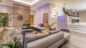 A modern living room with a sofa, coffee table, and decorative plants.
