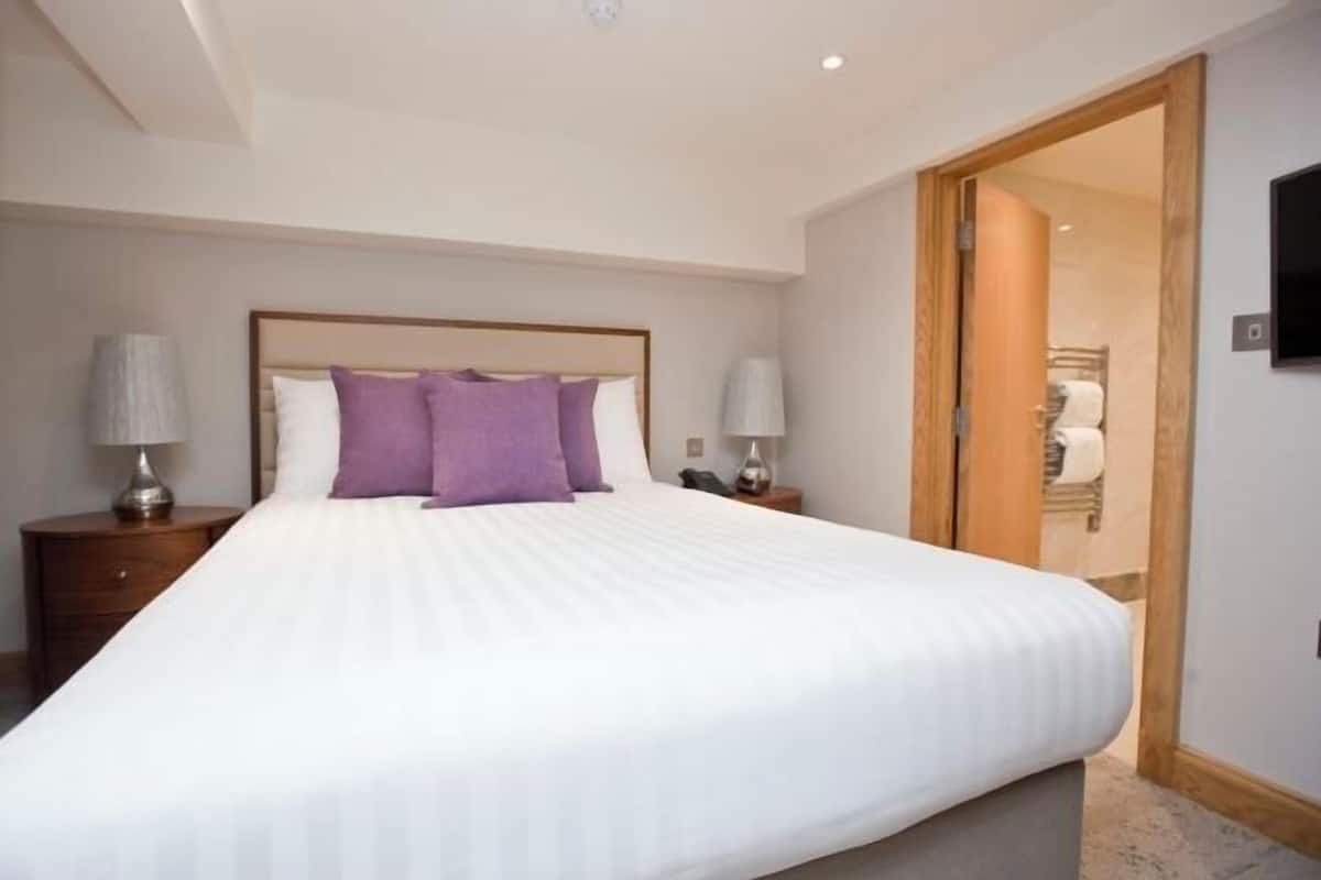 Ropa de cama de alta calidad y caja de seguridad en la habitación