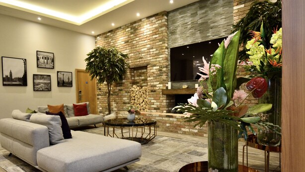 A modern living room with a sofa, a coffee table, and a fireplace.