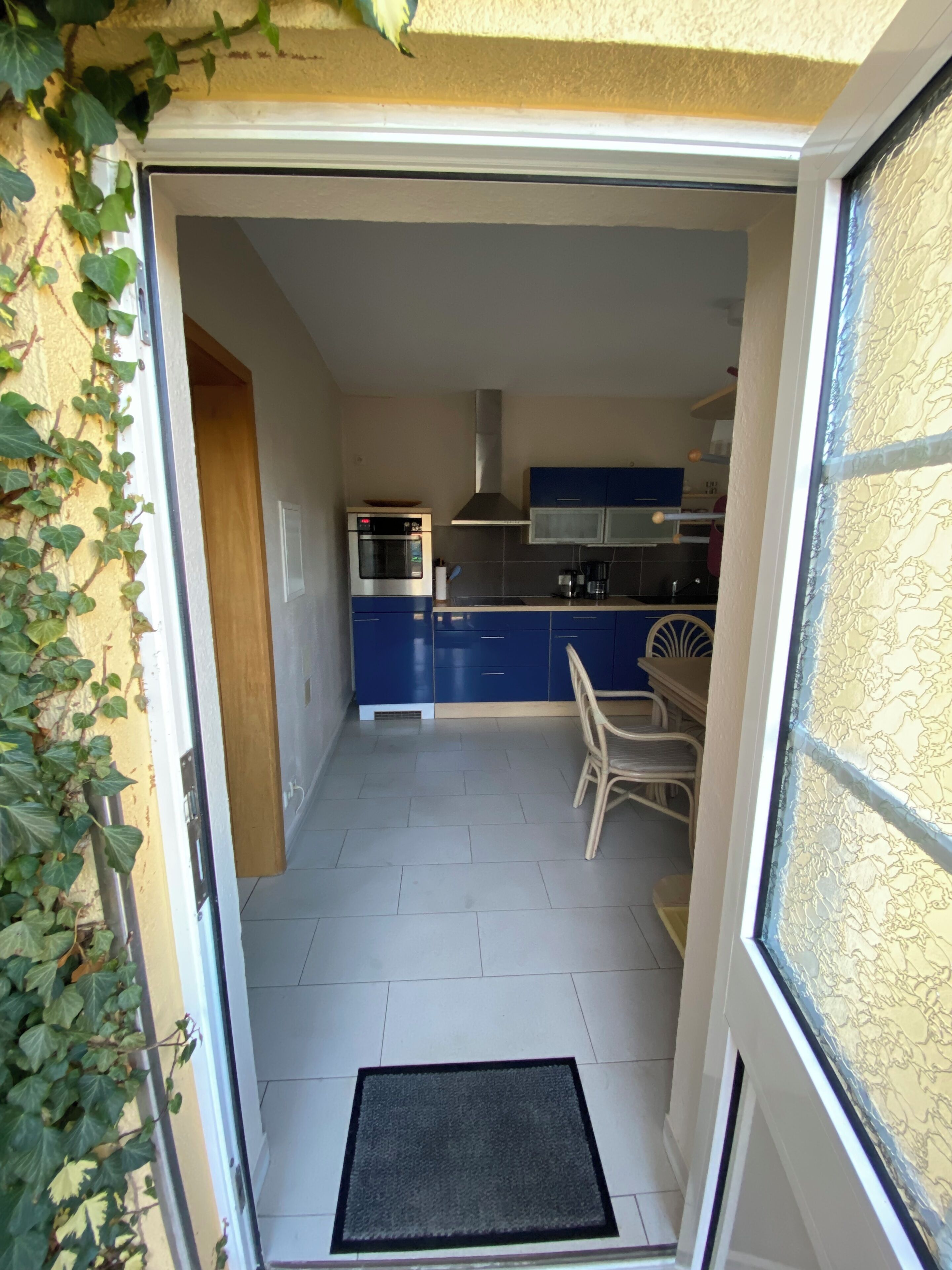 A compact kitchen with blue cabinets, a stainless steel oven, and a gas stove.