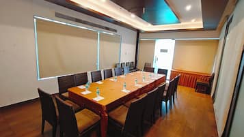A conference room with a long table, chairs, and water bottles.