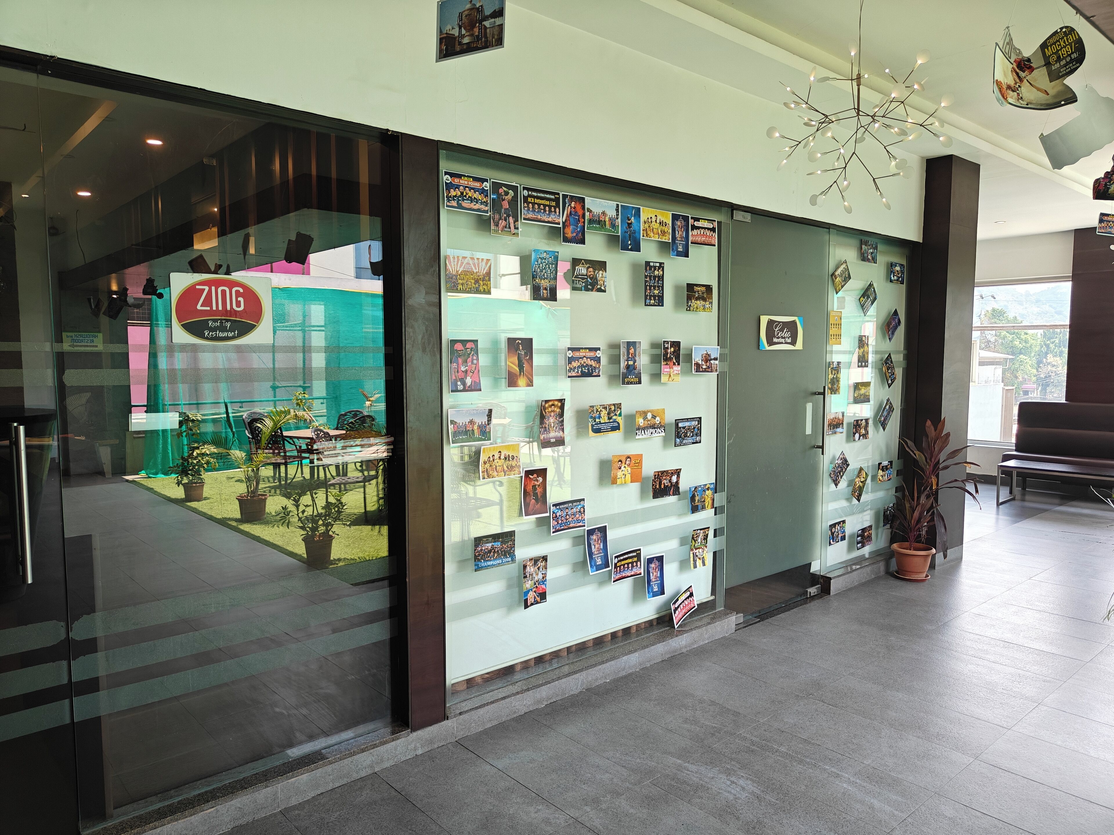 A restaurant named ZING with a glass display of various posters and photographs on the wall.