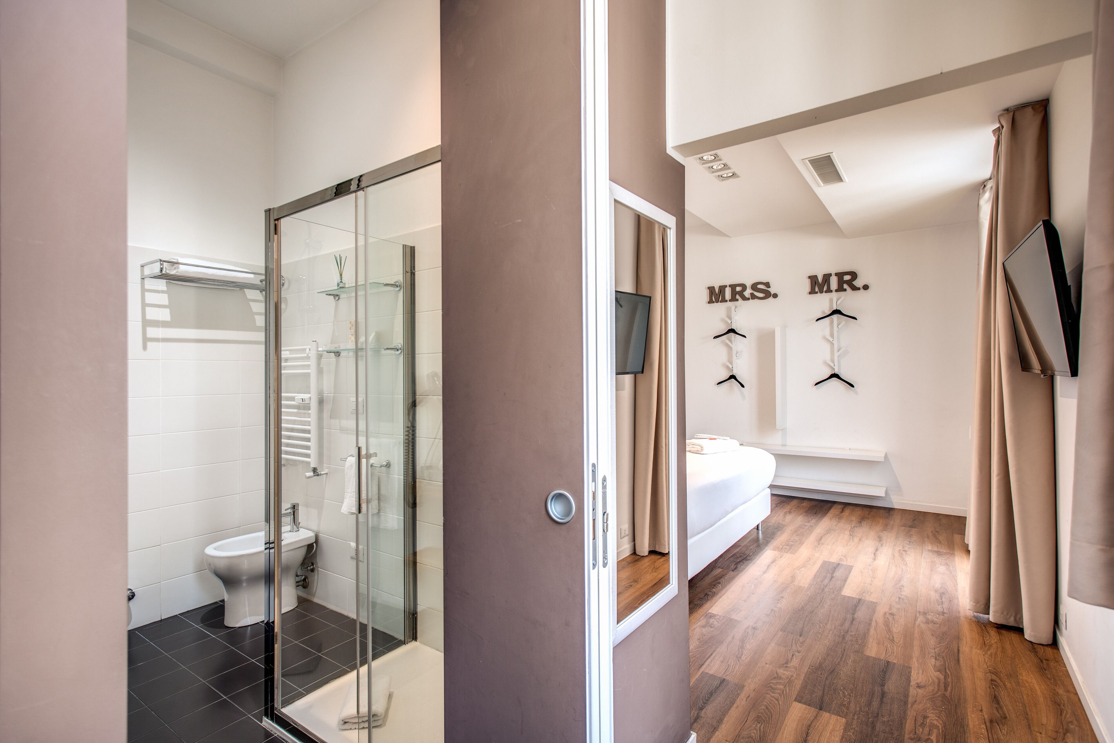 A modern bathroom with a glass shower enclosure, a toilet, and a sink.