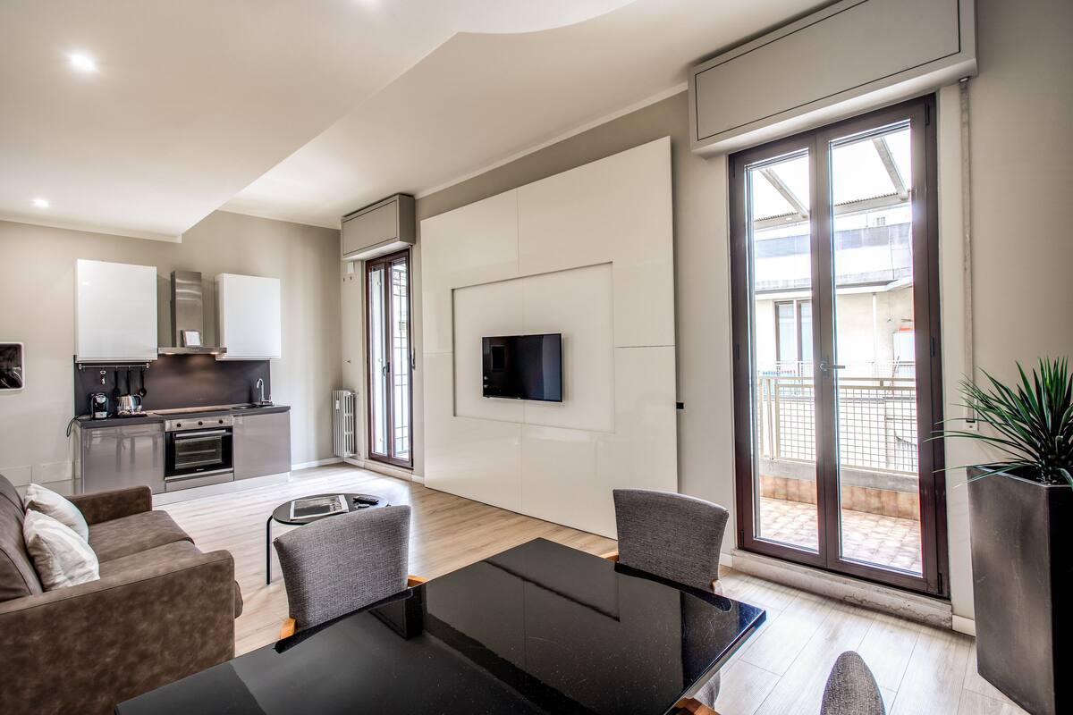 Un appartement moderne comprenant une cuisine, un coin repas et un salon.